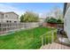Fenced-in backyard boasts lush green grass, perfect for outdoor activities and relaxation, with a deck right off the house at 4312 Windmill Dr, Brighton, CO 80601