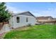Well-maintained backyard with lush green grass, side yard landscaping, and backyard deck at 4312 Windmill Dr, Brighton, CO 80601