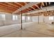 Unfinished basement, ready to be customized, with exposed ceiling and support beams and bright natural light from windows at 4312 Windmill Dr, Brighton, CO 80601