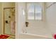 Bright bathroom featuring a soaking tub, a shower and a large window at 4312 Windmill Dr, Brighton, CO 80601