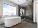 Modern bathroom featuring freestanding tub, marble tiled shower, and large window at 3112 Braun Ct, Golden, CO 80401