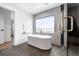Bright bathroom featuring freestanding tub, large window, and elegant finishes at 3112 Braun Ct, Golden, CO 80401