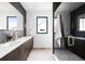 A modern bathroom features a double sink vanity with dark cabinets, a large mirror, and a glass enclosed shower at 3112 Braun Ct, Golden, CO 80401
