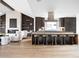 A modern kitchen features a central island with bar seating, a sleek range hood, and hardwood floors at 3112 Braun Ct, Golden, CO 80401