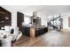 This open-concept kitchen features an island with bar seating, a modern hood, and hardwood floors at 3112 Braun Ct, Golden, CO 80401