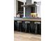 Kitchen island showcasing modern stools and stylish stainless steel hood at 3112 Braun Ct, Golden, CO 80401