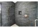 Modern shower features stylish dark tile, gold fixtures and shower head, and recessed niche at 3112 Braun Ct, Golden, CO 80401