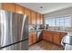 Charming kitchen equipped with stainless steel appliances, wooden cabinetry, and a view of the sink under a bright window at 23376 E 5Th Pl # 201, Aurora, CO 80018
