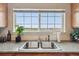 Kitchen sink featuring stainless steel basin and faucet, plus an external view through a window at 23376 E 5Th Pl # 201, Aurora, CO 80018