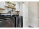 Modern laundry room with front-load washer and dryer, shelving, and ample storage space at 23376 E 5Th Pl # 201, Aurora, CO 80018