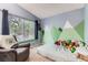 Bright bedroom with a mural, chair, and large window at 12556 Elm St, Thornton, CO 80241