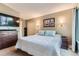 Comfortable bedroom with a queen bed, dresser, TV, and sconce lighting at 12556 Elm St, Thornton, CO 80241