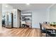 Bright dining area with wood floors, stainless steel refrigerator, and storage shelving at 12556 Elm St, Thornton, CO 80241