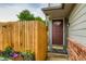 Inviting townhouse entrance with a red door, a vibrant flower box, and a wooden fence at 12556 Elm St, Thornton, CO 80241