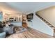Cozy living room with hardwood floors, grey sofa, and stairs leading to the upper level at 12556 Elm St, Thornton, CO 80241