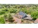 Aerial shot of barn with solar panels, enclosed horse pen, and fenced garden at 9053 Clydesdale Rd, Castle Rock, CO 80108