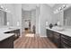 Bright bathroom featuring dual vanities, wood cabinets, and a large central doorway at 9053 Clydesdale Rd, Castle Rock, CO 80108