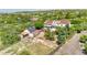 Expansive property featuring a white home, horse barn with solar panels, and fenced pasture, all surrounded by lush greenery at 9053 Clydesdale Rd, Castle Rock, CO 80108