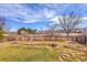 Spacious backyard featuring a well-maintained lawn, flower beds, and a wooden fence at 13124 Ivy Pl, Thornton, CO 80602