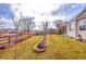 View of the backyard showcasing a green lawn, trees, and garden beds with a brick border at 13124 Ivy Pl, Thornton, CO 80602