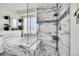 Bright bathroom featuring a tub with marble tile surround and glass-enclosed shower with mosaic accents at 13124 Ivy Pl, Thornton, CO 80602