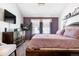 Spacious main bedroom with a large bed, dresser, and TV at 961 S Evanston Cir, Aurora, CO 80012