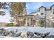 Townhouse exterior with snowy landscaping and stone wall at 961 S Evanston Cir, Aurora, CO 80012