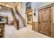 Grand foyer featuring a staircase, stone floors, and wood accents at 8576 Niwot Meadow Farm Rd, Niwot, CO 80503