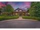 Stunning stone-clad home featuring a covered front porch and walkway lined by trimmed shrubs at 8576 Niwot Meadow Farm Rd, Niwot, CO 80503