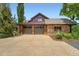 Two car garage featuring wood doors, stone and wood siding, and a concrete driveway at 8576 Niwot Meadow Farm Rd, Niwot, CO 80503