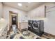 Modern laundry room featuring a washer, dryer, cabinets, countertop space, and stylish flooring at 8576 Niwot Meadow Farm Rd, Niwot, CO 80503