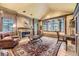 Elegant living room with wood paneling, fireplace, and large bay window showcasing natural light and scenic views at 8576 Niwot Meadow Farm Rd, Niwot, CO 80503