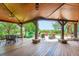 Outdoor patio with a wood ceiling, stone pillars, and dining and lounge areas at 8576 Niwot Meadow Farm Rd, Niwot, CO 80503