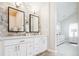 Bright bathroom with a double vanity, large mirrors, and modern lighting fixtures at 175 S Jasmine St, Denver, CO 80224