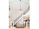 Grand foyer with a spiral staircase, a modern chandelier, and light hardwood floors at 175 S Jasmine St, Denver, CO 80224