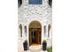 The front entrance has double wooden doors, surrounded by unique stone accents and arched windows at 175 S Jasmine St, Denver, CO 80224