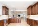 Well-lit kitchen with dark wood cabinetry, stainless steel appliances, and a view to the open living space at 175 S Jasmine St, Denver, CO 80224
