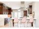 Modern kitchen with stainless steel appliances, dark wood cabinets, white countertops and three bar stools at 175 S Jasmine St, Denver, CO 80224