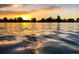 Sunset on calm lake waters, reflecting the sky and surrounding trees at 4760 W Evans Ave, Denver, CO 80219