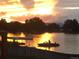 Picturesque lake at sunset, featuring people enjoying a boat ride and a dock canopy, for relaxation at 4760 W Evans Ave, Denver, CO 80219