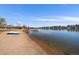 Calm waterfront view features a sandy beach, clear water, and homes lining the lake shoreline at 4760 W Evans Ave, Denver, CO 80219