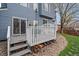 Gray wood back deck with stairs leading down to the grass and sliding glass doors leading inside at 5486 S Cathay Way, Centennial, CO 80015