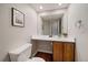 Bathroom features a single sink vanity with wooden cabinets, a mirror, a toilet, and hardwood floors at 5486 S Cathay Way, Centennial, CO 80015