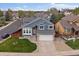 Charming blue two-story home boasts a manicured lawn, stone accents, and an attached two-car garage at 5486 S Cathay Way, Centennial, CO 80015