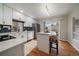 Bright kitchen with white cabinetry, island with seating, stainless steel appliances, and updated backsplash at 5486 S Cathay Way, Centennial, CO 80015