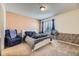 Cozy bedroom with a comfortable recliner, fan and a window offering natural light at 3596 S Depew St # 2, Lakewood, CO 80235