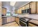 Traditional kitchen with wooden cabinets, stainless steel appliances, and tiled backsplash at 3596 S Depew St # 2, Lakewood, CO 80235