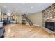 Open-concept living area featuring hardwood floors, a stone fireplace, and staircase at 3596 S Depew St # 2, Lakewood, CO 80235