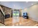 Bright living room featuring a stone fireplace, hardwood floors, and a TV at 3596 S Depew St # 2, Lakewood, CO 80235