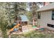 Playground in backyard with slide and climbing wall next to exterior of home at 8795 Rudd Rd, Evergreen, CO 80439